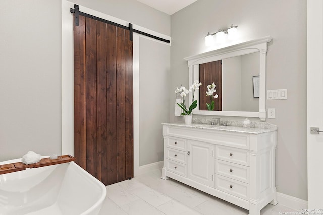 bathroom featuring marble look tiles, vanity, and baseboards