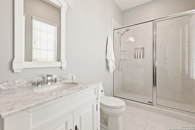 full bath featuring a marble finish shower, toilet, marble finish flooring, and vanity