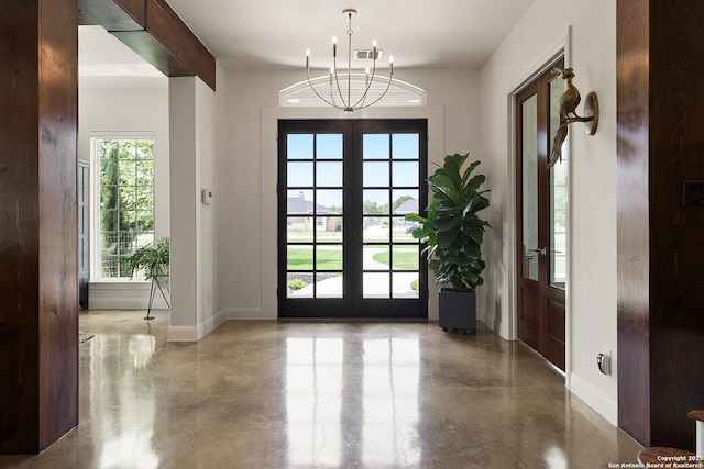 entryway featuring french doors, finished concrete floors, a chandelier, and baseboards