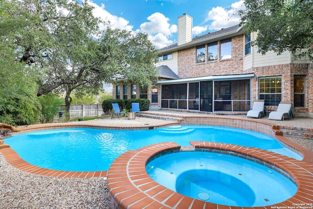 view of pool with an in ground hot tub, a sunroom, and a patio