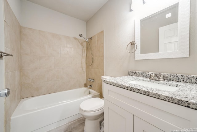 full bathroom with vanity, hardwood / wood-style floors, tiled shower / bath combo, and toilet