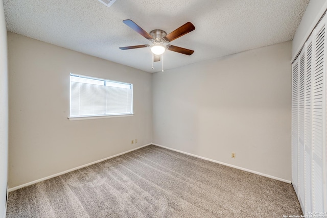 unfurnished bedroom featuring ceiling fan, carpet floors, a closet, and a textured ceiling