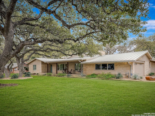 ranch-style home featuring a garage, covered porch, and a front yard