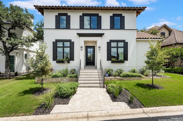 mediterranean / spanish house with a front lawn