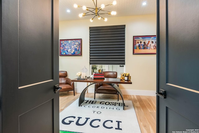 home office with a chandelier and light hardwood / wood-style floors