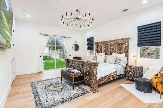 bedroom featuring access to exterior, a chandelier, and light wood-type flooring