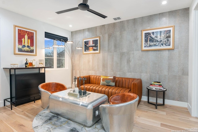 living room with light hardwood / wood-style floors and ceiling fan