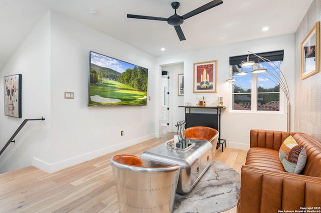 living area with ceiling fan and light hardwood / wood-style flooring