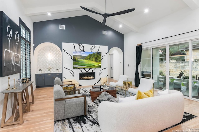 living room with beamed ceiling, ceiling fan, high vaulted ceiling, and light hardwood / wood-style floors