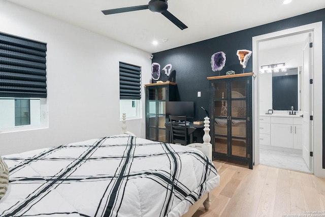 bedroom with ensuite bathroom and light wood-type flooring