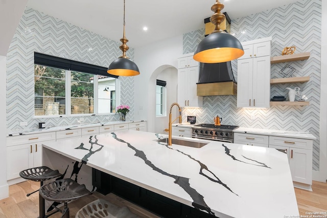 kitchen with pendant lighting, high end stainless steel range oven, and white cabinets