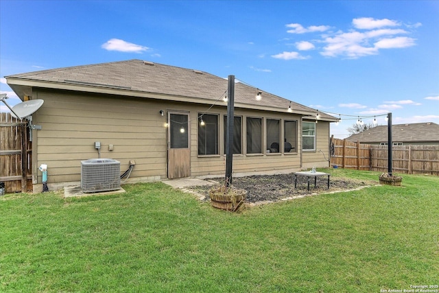 back of property with a yard and central AC