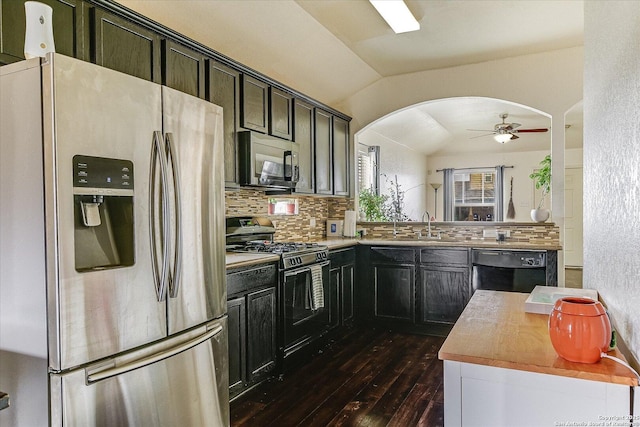 kitchen featuring vaulted ceiling, kitchen peninsula, backsplash, and black appliances