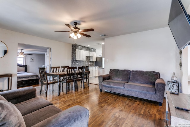 living room with dark hardwood / wood-style flooring and ceiling fan