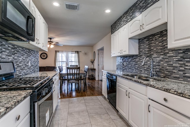 kitchen featuring sink, black appliances, dark stone countertops, ceiling fan, and white cabinets