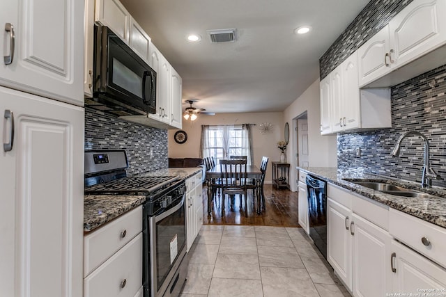 kitchen featuring white cabinets, dark stone counters, sink, and black appliances