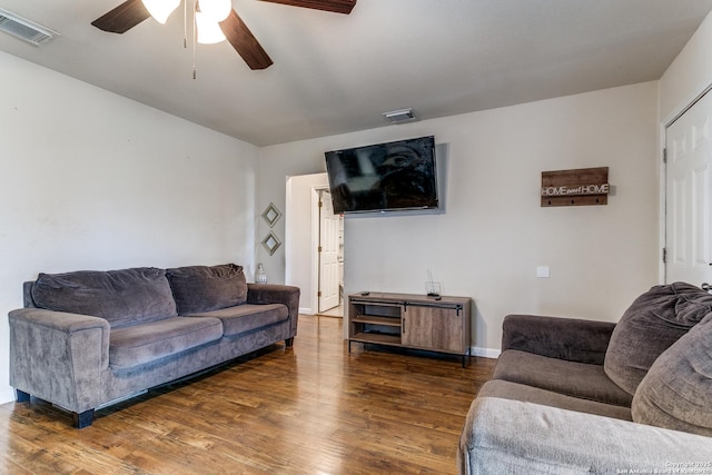 living room featuring dark wood-type flooring and ceiling fan