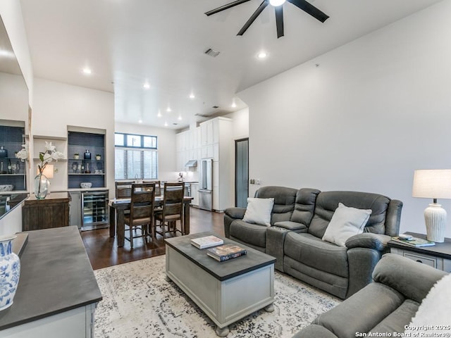 living room featuring ceiling fan, beverage cooler, and light hardwood / wood-style floors