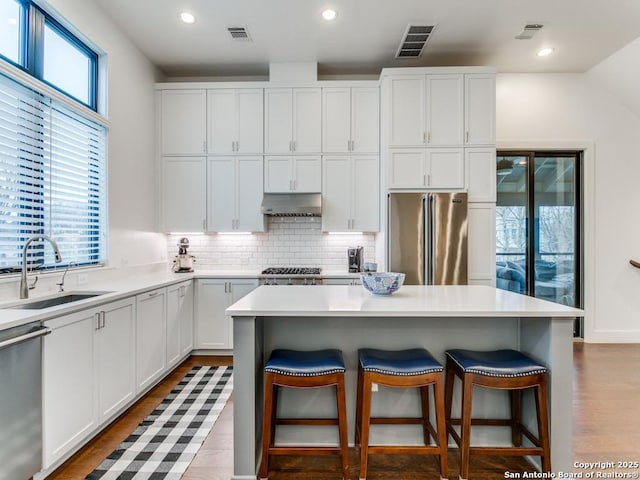 kitchen featuring white cabinetry, appliances with stainless steel finishes, sink, and a kitchen island