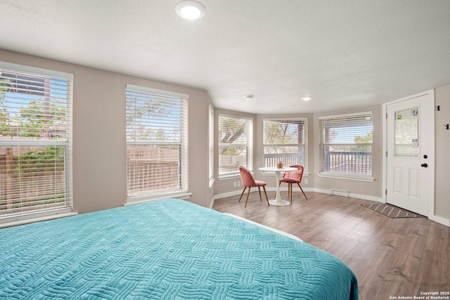 bedroom with hardwood / wood-style floors and a textured ceiling