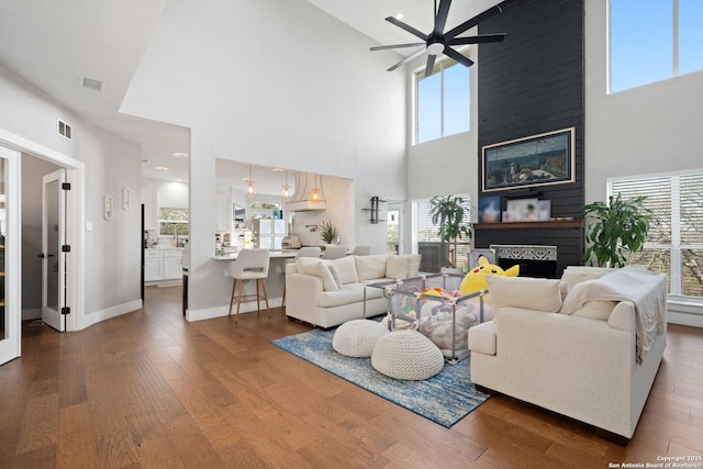 living room featuring ceiling fan and dark hardwood / wood-style flooring