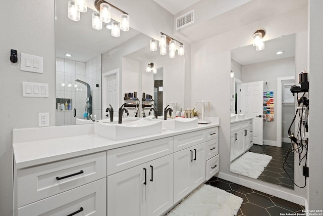 bathroom with a shower with door, vanity, and tile patterned floors