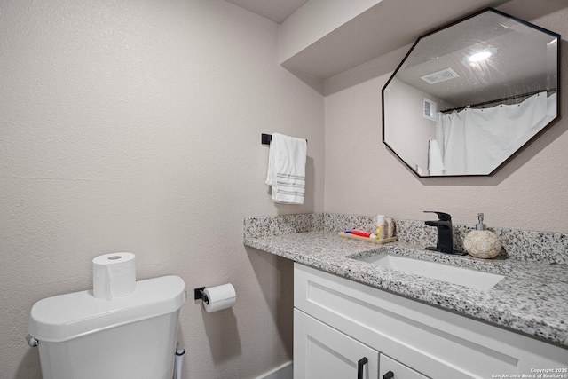 bathroom featuring vanity and toilet