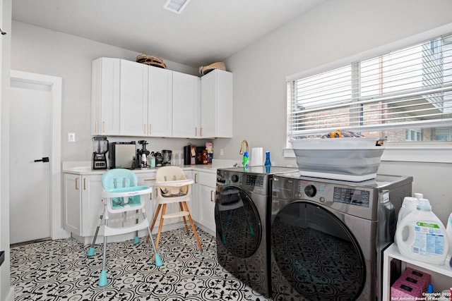 laundry area with cabinets, light tile patterned flooring, and washer and clothes dryer