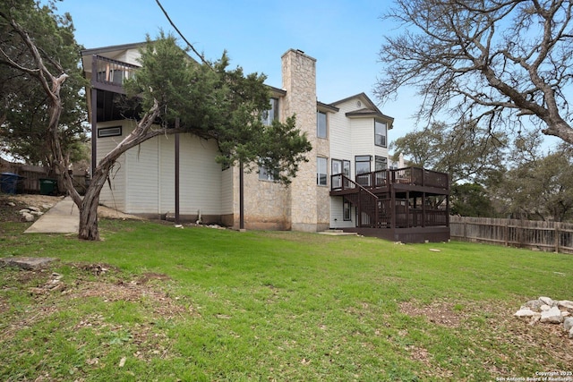 back of property featuring a wooden deck and a lawn