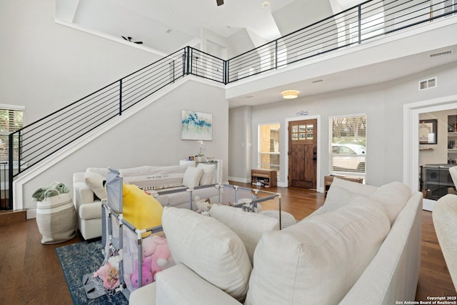 living room with dark hardwood / wood-style flooring and a towering ceiling