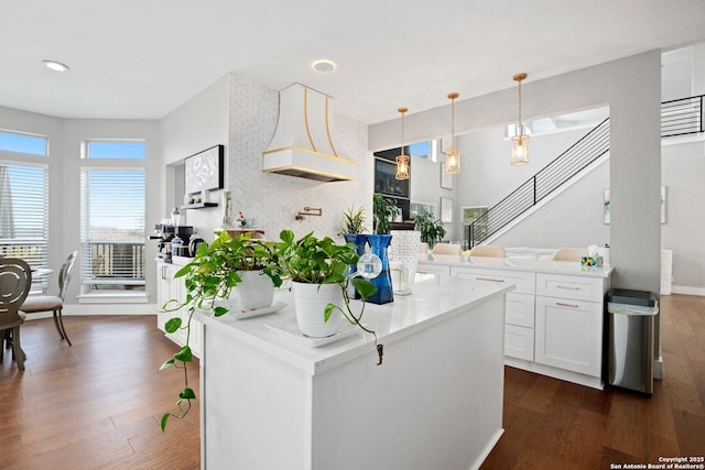 kitchen with decorative light fixtures, kitchen peninsula, dark hardwood / wood-style floors, and white cabinets