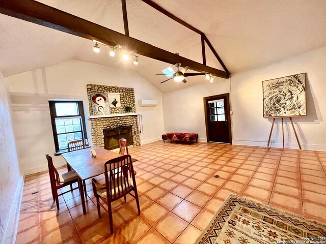 dining room featuring ceiling fan, vaulted ceiling with beams, a wall mounted air conditioner, a large fireplace, and a textured ceiling