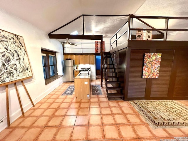 kitchen featuring sink, stainless steel fridge, kitchen peninsula, and high vaulted ceiling