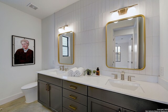 bathroom with tile walls, vanity, and toilet