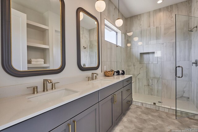 bathroom with built in shelves, vanity, and a shower with door