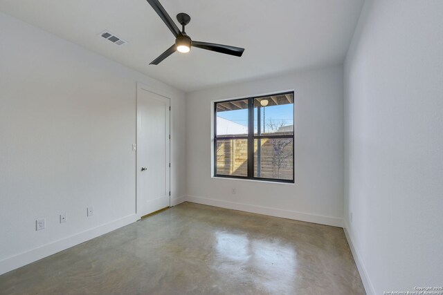 unfurnished room with ceiling fan and concrete flooring