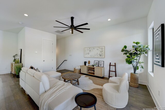 living room featuring dark wood-type flooring and ceiling fan