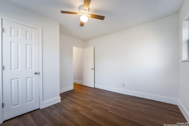 unfurnished bedroom featuring ceiling fan and dark hardwood / wood-style flooring