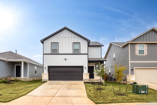 view of front of property featuring a garage, central AC unit, and a front lawn