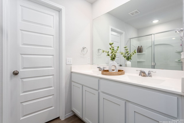 bathroom featuring vanity and a shower with shower door