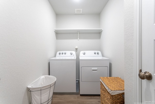 laundry area featuring hardwood / wood-style flooring and washing machine and dryer