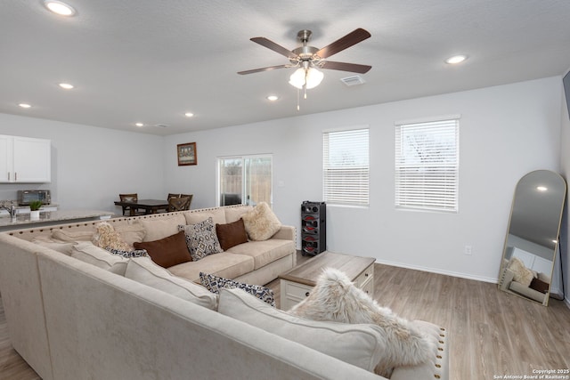 living room featuring ceiling fan and light wood-type flooring