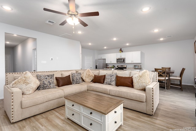 living room featuring ceiling fan and light wood-type flooring