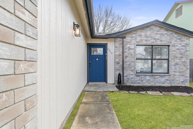 doorway to property featuring a lawn