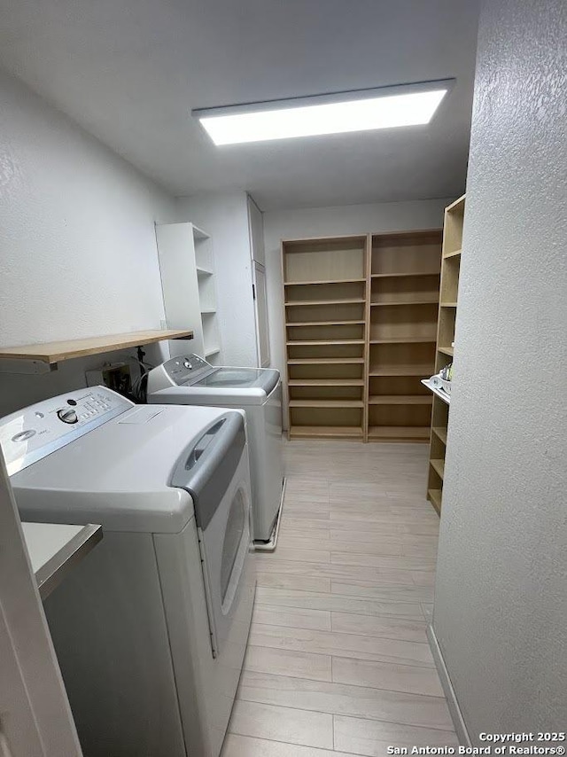 clothes washing area with washing machine and dryer