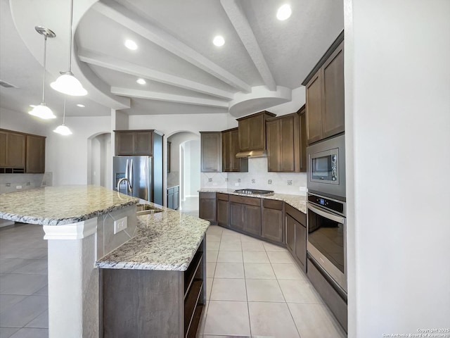 kitchen featuring stainless steel appliances, hanging light fixtures, light tile patterned floors, and decorative backsplash