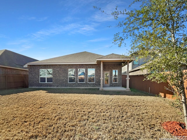 back of house featuring a patio and a yard