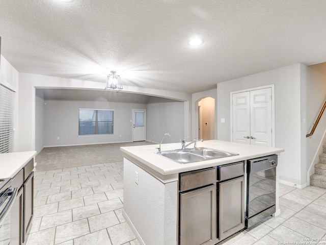 kitchen featuring black dishwasher, sink, electric range, a center island with sink, and a textured ceiling