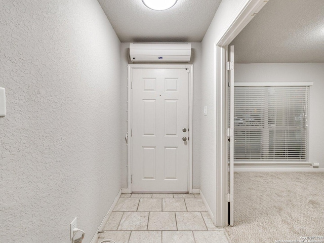 doorway with a wall mounted AC and a textured ceiling