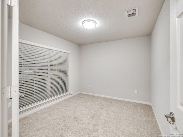 carpeted spare room featuring a textured ceiling